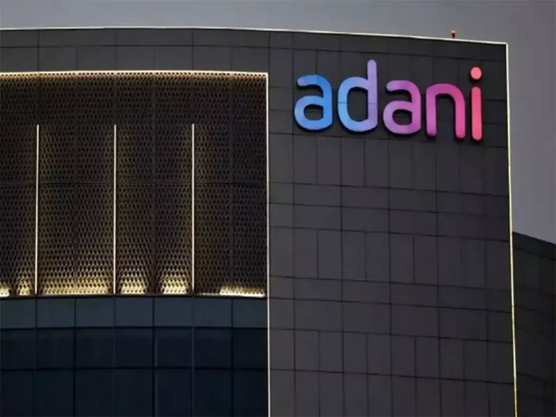Adani Enterprises building with stock market graphs overlay