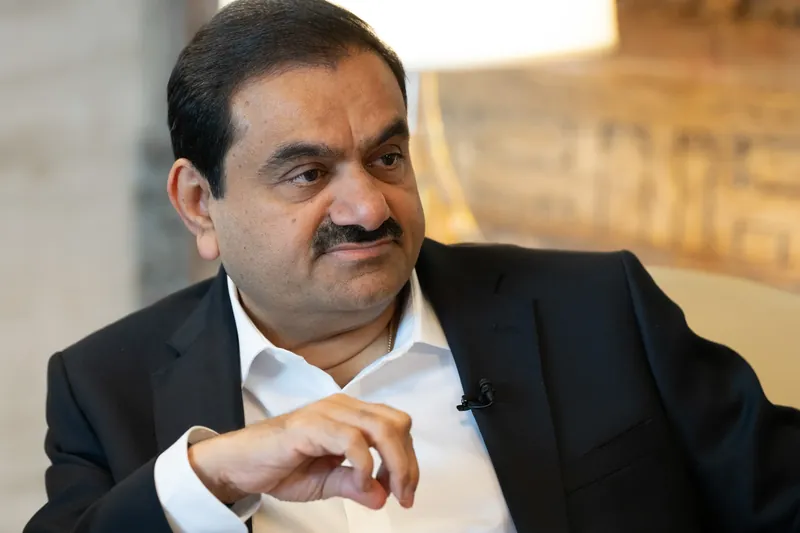 Adani Group headquarters with stock market graph overlay