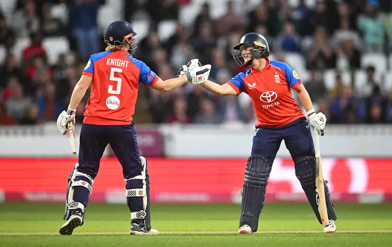 Alice Capsey and Heather Knight celebrating a cricket victory