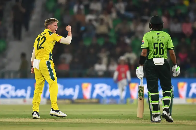 Australian cricket players celebrating a wicket during a match.