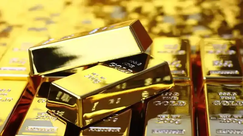 Gold bars stacked with a fluctuating graph in the background