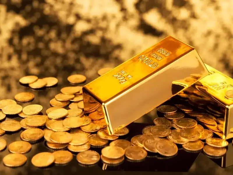 Gold bars and coins with fluctuating market graph