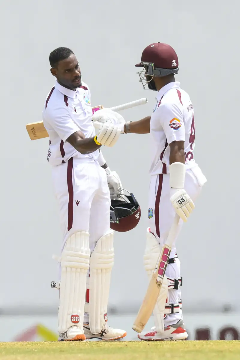 Shai Hope and Justin Greaves celebrating a successful partnership on the cricket field