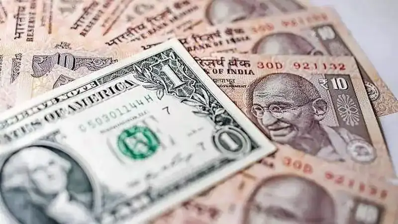 Indian rupee notes and US dollar bills in a financial setting